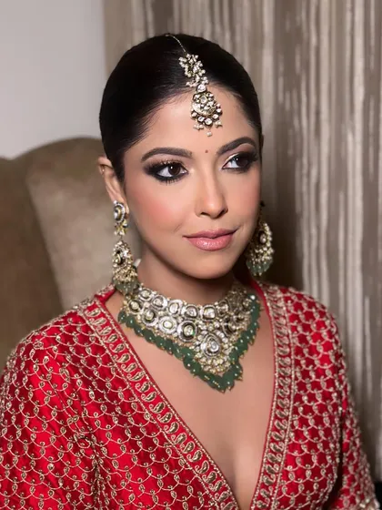 A close-up of the kohl-rimmed eyes and flawless skin. This makeup look is designed to be both striking and sophisticated, enhancing the bride's features beautifully.