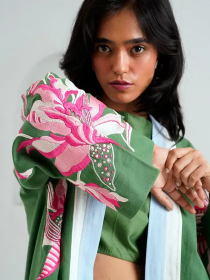 A close-up of the Socotra Ornamental collection by Madder Much, showcasing the beautiful floral embroidery on the sleeve of a green jacket.