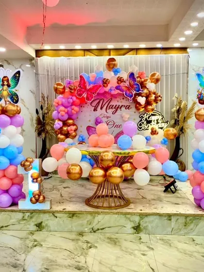 The complete stage setup for the butterfly-themed first birthday. The mix of pastel and metallic balloons, along with the fairy and butterfly cutouts, creates a truly enchanting scene.