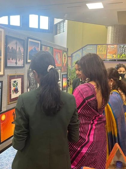 Students and guests admiring the gallery wall at an art exhibition we participated in. Seeing their work professionally framed and displayed is a huge confidence booster for any artist.