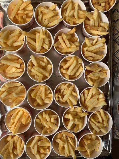 A tray of french fries portioned into individual cups.