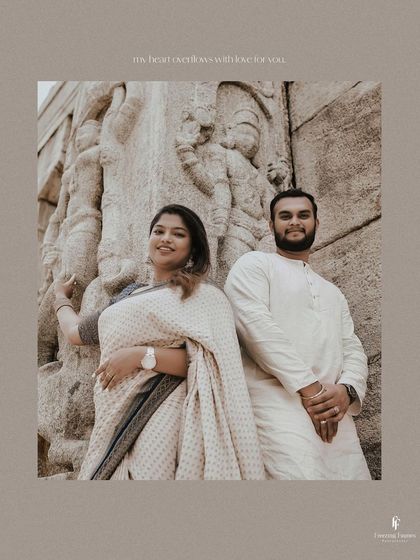 A classic couple's portrait set against intricately carved temple stone. Their coordinated white outfits and the timeless background create a truly elegant maternity photograph.
