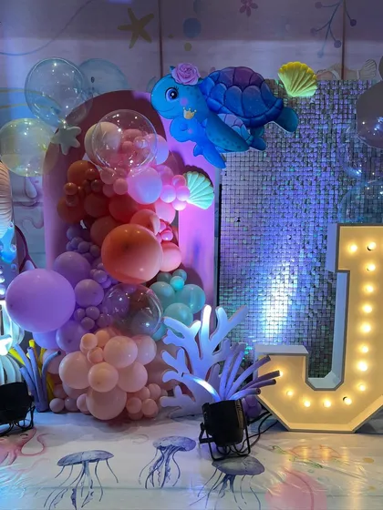 For Jivana and Janya's first birthday, we created another enchanting under-the-sea world, featuring marquee letters, iridescent backdrops, and a soft play area for the tiniest guests.