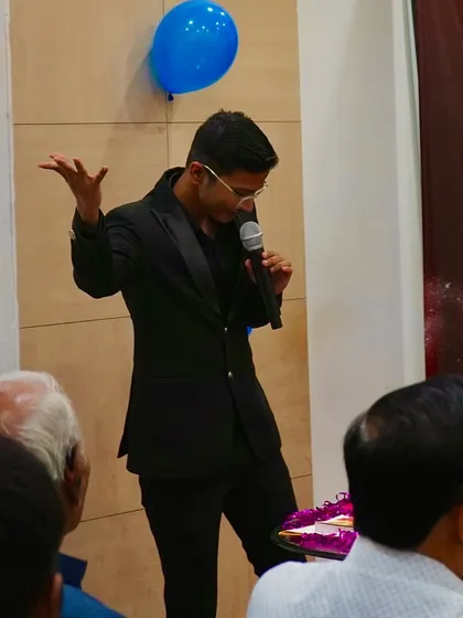 On stage at the Kusum Healthcare event, explaining the principles of psychological illusion to an engaged audience.