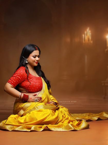 A classic pose in a yellow saree, set against a candle-lit backdrop. This image creates a warm, intimate, and almost divine atmosphere.
