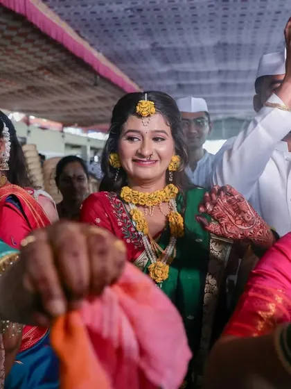The bride makes her entrance at the Haldi ceremony, surrounded by the smiling faces of her family and friends.