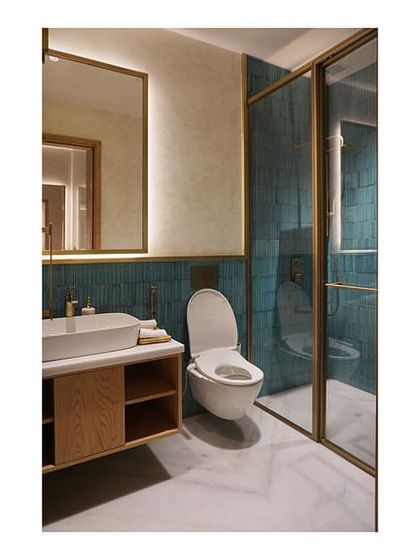 The bathroom in the Departure Lounge at Bangalore airport features a green ceramic tile accent wall and a custom vanity. The design is clean and modern, with one of the two bathrooms being fully accessible.