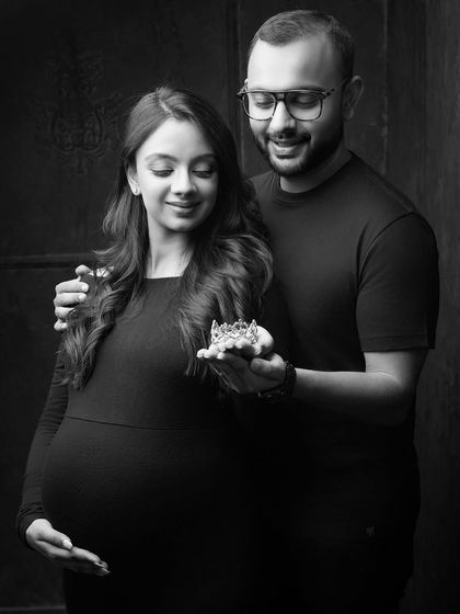 This black and white portrait captures a symbolic moment, with the couple gently holding a tiny crown. It’s a beautiful, artistic way to represent the little one you're waiting for.