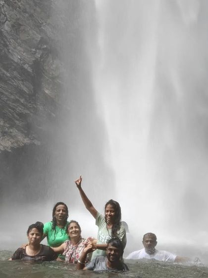 A group having fun in the water at Koodluthirtha Falls.