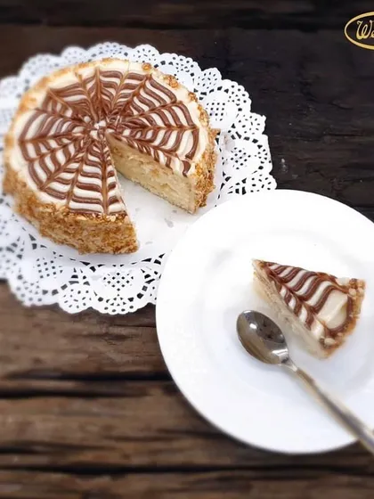 A slice of our delightful Butterscotch Cake. This cake features a soft sponge, crunchy nougat, and a smooth butterscotch cream, finished with a classic web design.
