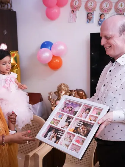 The little princess herself, looking curiously at the frame that holds all her first-year memories. A gift she will treasure as she grows.