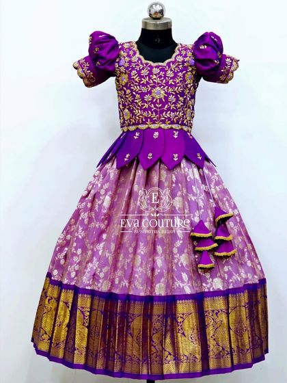 A regal purple Banarasi lehenga. The blouse is heavily embroidered, and the skirt features a beautiful floral brocade pattern with a wide gold zari border.