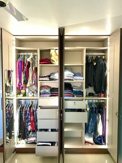 Our custom wardrobes are designed to fit your specific needs. This one features ample space for both hanging and folded clothes, with bright LED lighting to make finding items easy.