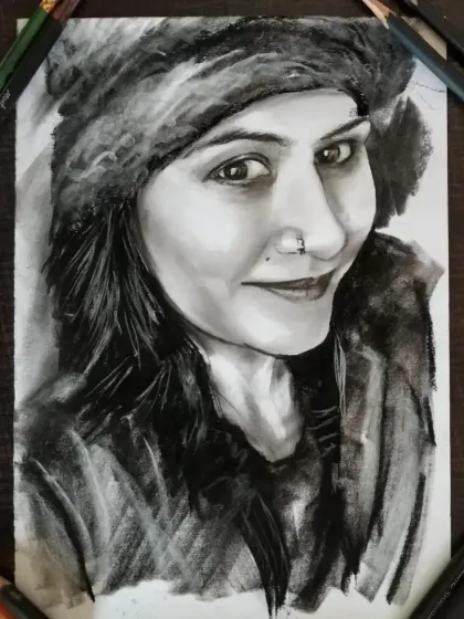 A charcoal sketch of a client wearing a winter hat. The texture of the fur and the soft shading on her face are key details.