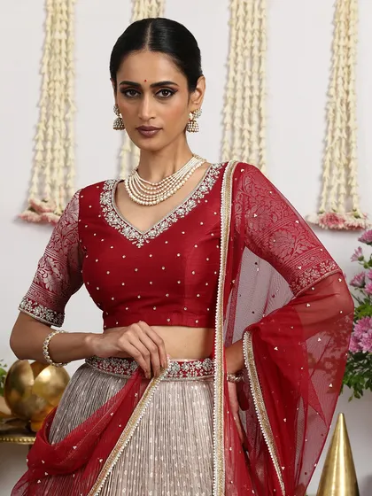 A close-up of our maroon embroidered blouse, paired with a beige pleated silk lehenga. The intricate embroidery is a hallmark of our brand.