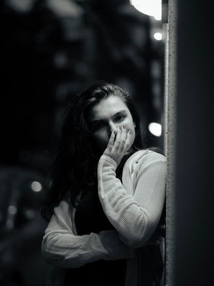 A mysterious black and white portrait. Covering part of the face can create a sense of intrigue and draw the viewer's attention to the eyes.