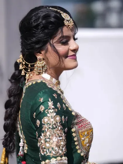 A side view of the carnival look, showcasing the intricate braided hairstyle with traditional accessories.
