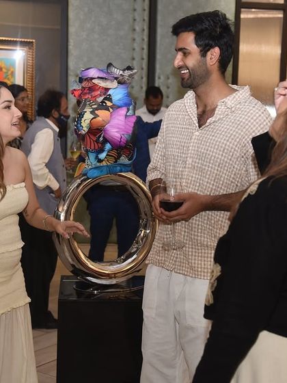 A group of guests gathered around a colorful sculpture, engaged in lively discussion. Our events are designed to be social hubs where art becomes the central topic of conversation.