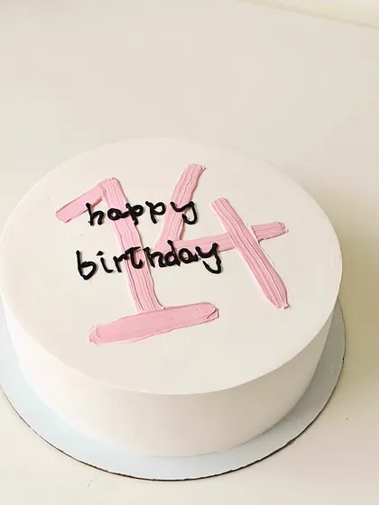 A trendy and minimalist Korean-style cake for a 14th birthday. The clean white frosting and simple pink brushstroke lettering create a chic and understated look.