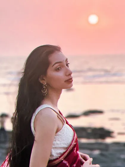 Modeling a beautiful bandhani saree against a Mumbai sunset. The soft light and beach backdrop create a serene and romantic mood, perfect for showcasing evening or resort wear.