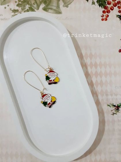Get into the festive spirit with these Santa Claus charm hoop earrings. They are a fun and jolly accessory for the Christmas season.
