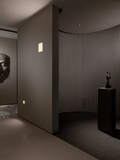 We use lighting to create distinct zones and moods. Here, wall-washing lights and focused spotlights draw attention to art pieces and architectural details, guiding the visitor's journey.