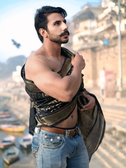 A classic, strong pose against the backdrop of the ghats, with a bird in flight adding a touch of serendipity to this Banaras portrait.