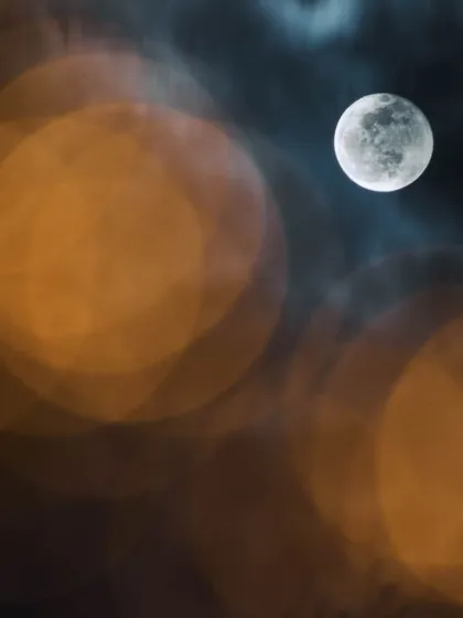 This image of the moon was an early experiment with multiple exposures. I combined a long exposure to capture the soft clouds with a faster one to retain the moon's detail, creating a composite image with beautiful foreground bokeh from city lights.
