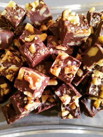 A close-up of my decadent Walnut Chocolate Fudge. These bite-sized treats are gooey, rich, and packed with walnuts, making them a perfect winter indulgence or a sweet gift for someone special.