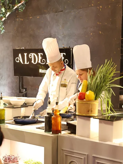 Our Italian chefs in action at the "Al Dente" live pasta station, sautéing ingredients with precision and passion.
