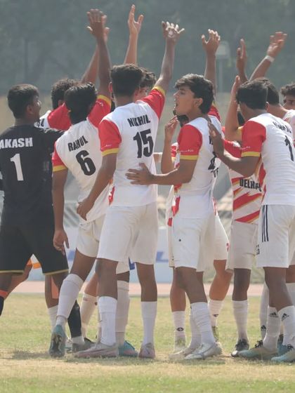 Hands in, ready to break. The team shows their unity and excitement before taking the field.