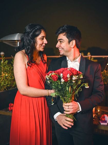 A romantic portrait of the newly engaged couple, sharing a sweet look, with the city lights twinkling in the background.