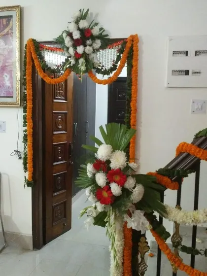 A simple and traditional flower decoration for a Grihaparvesh (housewarming) ceremony. We decorated the main door with marigold garlands and placed flower bouquets on the staircase railing to welcome guests.