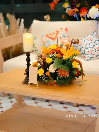 A simple yet elegant table centerpiece. A basket of colorful flowers and a single candle create a warm and inviting atmosphere for guests.