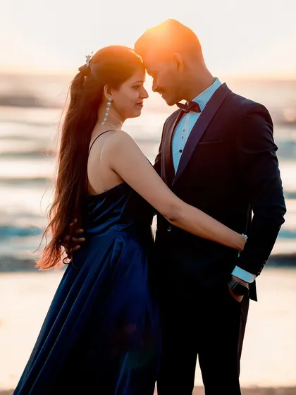 An intimate close-up of a couple during their beach pre-wedding shoot, with the golden hour sun creating a perfect backlight.