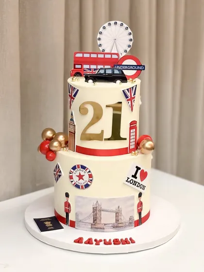 A 21st birthday cake full of London dreams! This two-tiered cake is decorated with iconic London landmarks like the red bus, Tower Bridge, and the London Eye to celebrate a new journey.