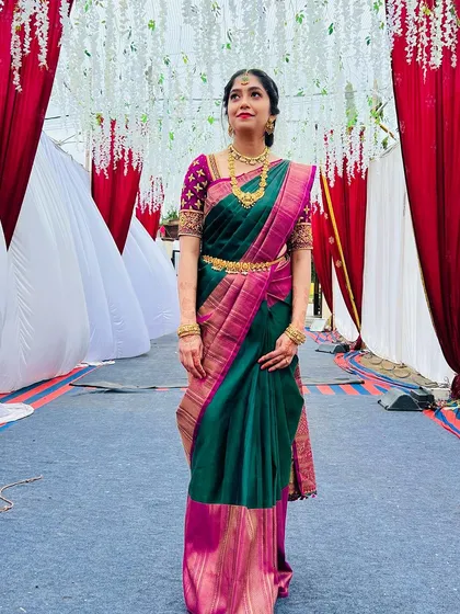 This image showcases the beautiful drape of the saree and the elegant, understated makeup perfect for a family member.