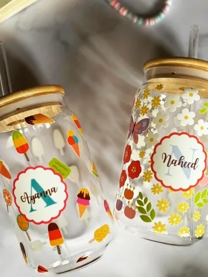 A pair of our themed can glass tumblers, one with an ice cream theme and the other with a floral theme. We can create any design you can dream of.