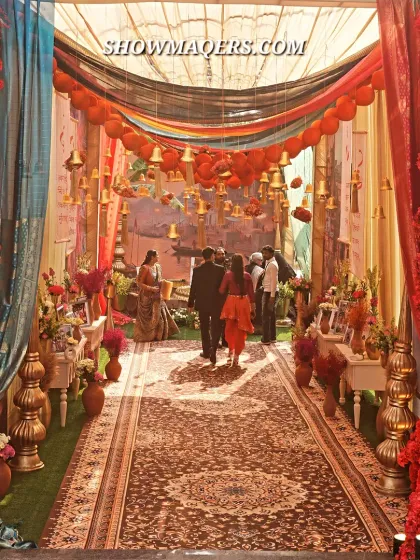For a truly unique Mehendi, we designed this immersive Banaras ghat themed entrance. The vibrant red floral walls, traditional temple bells, and intricate carpet runner transported guests to the ancient city, setting the stage for a culturally rich celebration.