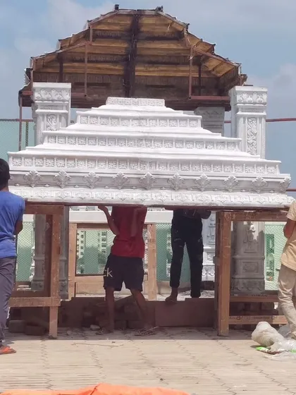 The final, heavy roof section of the mandir being carefully maneuvered into place by our dedicated team.