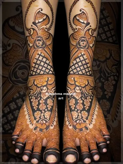 An elaborate design for bridal feet with a focus on floral and peacock motifs. The use of dark, bold lines creates a striking contrast and ensures the intricate details are clearly visible.