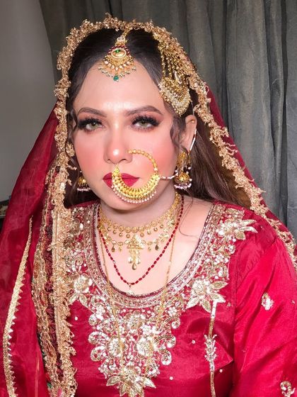 A portrait of the bride, showcasing the complete look with her head covered by the dupatta.