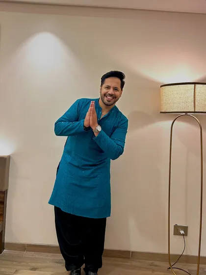 A respectful 'namaste' pose. It's a blend of modern energy and traditional values.