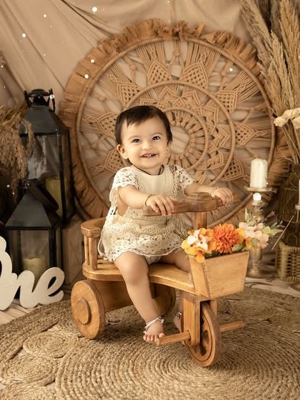 A first birthday shoot with a rustic, bohemian theme. The natural textures of wood, jute, and dried grasses create a warm and earthy setting for this little one's portraits.