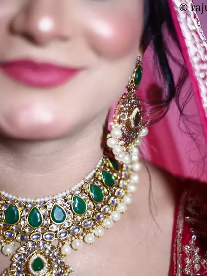 A close-up shot focusing on the bride's magnificent emerald and pearl necklace. Highlighting the details of the wedding jewelry is key to telling the full story of the bridal look.
