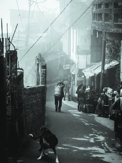 a black and white photo of a foggy alley. the depth and layers in this street scene are similar to how i approach layering elements in a user interface.