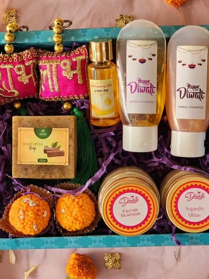 A top-down view of my premium Diwali hamper, showing the beautiful arrangement of products. It features Shubh Labh hangings, ubtan soap, abhyang oil, herbal shampoo, facewash, and ladoo candles.