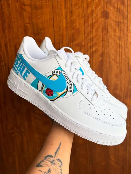 Holding up the finished Manchester City "Treble Winners" custom sneakers. So happy with how clean this pair turned out.