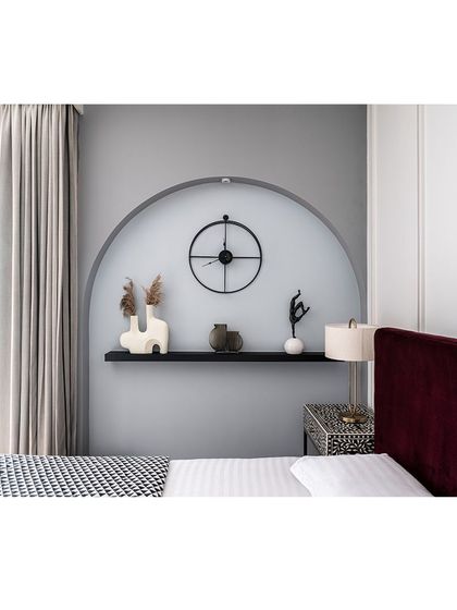 A close-up of the arched niche beside the bed, which serves as a frame for curated decor. The light blue-grey wall color adds a subtle, calming undertone to the room.