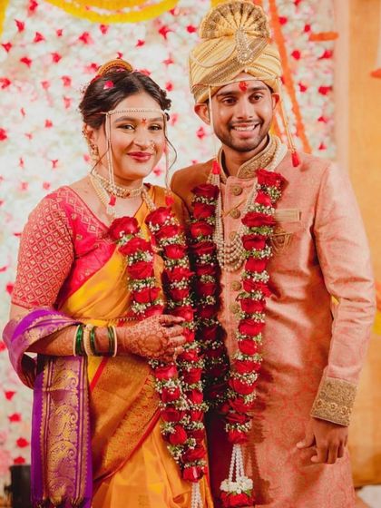 A happy couple on their wedding day. The bride's makeup is traditional and radiant, perfectly complementing her yellow and red saree.